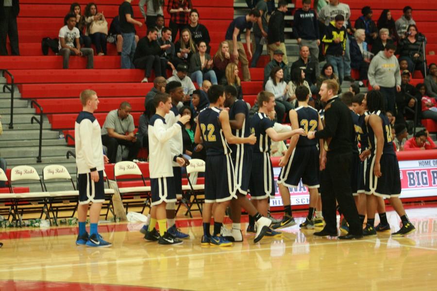 Ramblers players slap hands with one of the assistant coaches Monday night.