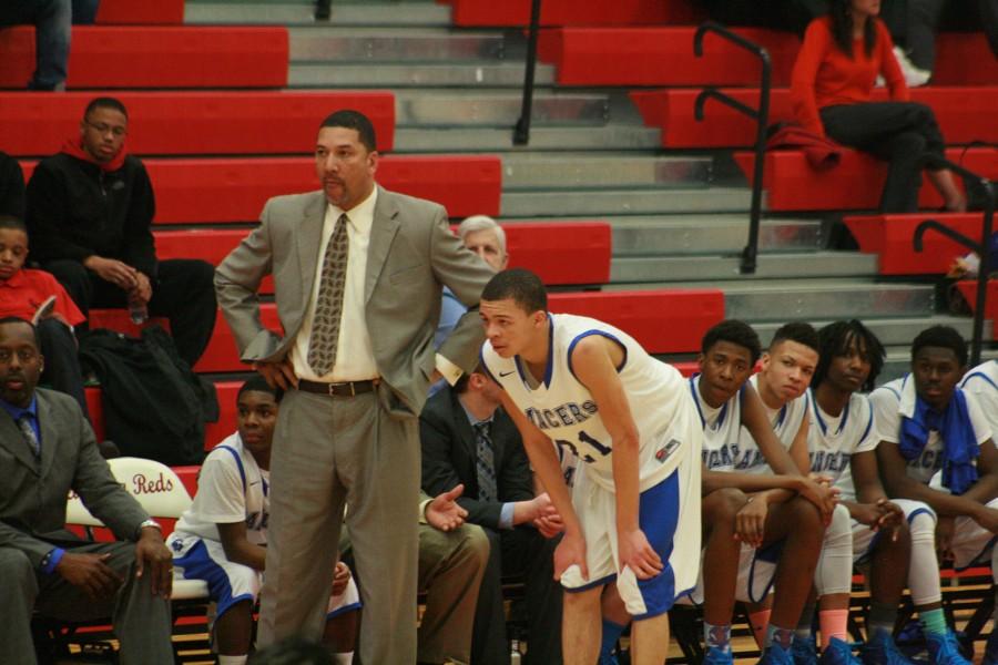 Junior Adam Samuel (21) of L'Anse Creuse stands next to coach George Woods after fouling out.