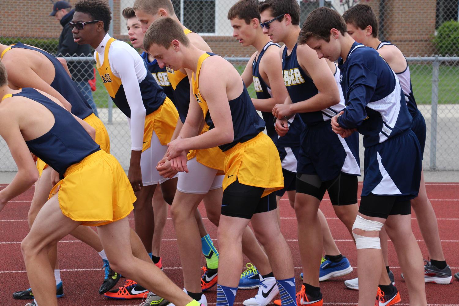 After he took off his warm up gear and tied his spikes, Ben is ready for the race. He and other participants crowd around as they hear for the starters call. Then starter sounds his gun and they are off. 