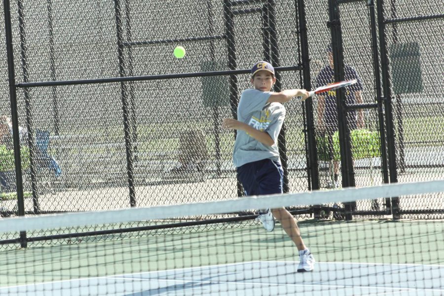 Ethan Wu (varsity) hitting the ball back to his opponent.